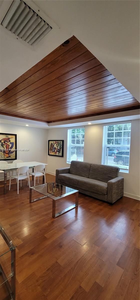 a living room with furniture wooden floor and windows