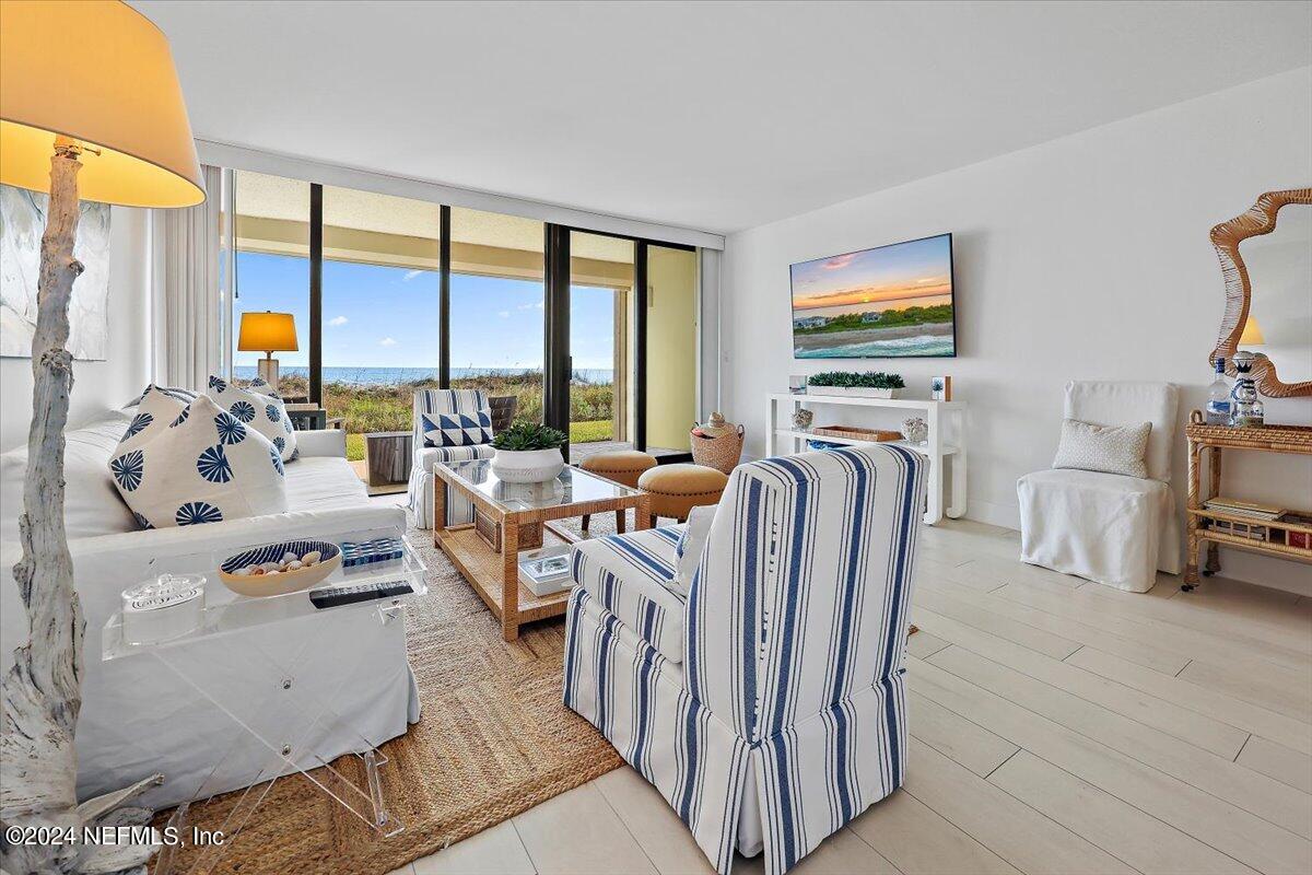 a living room with furniture a flat screen tv and a floor to ceiling window