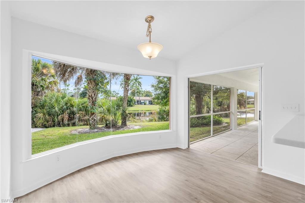 Unfurnished dining area with lofted ceiling, hardwood / wood-style floors, and a wealth of natural light