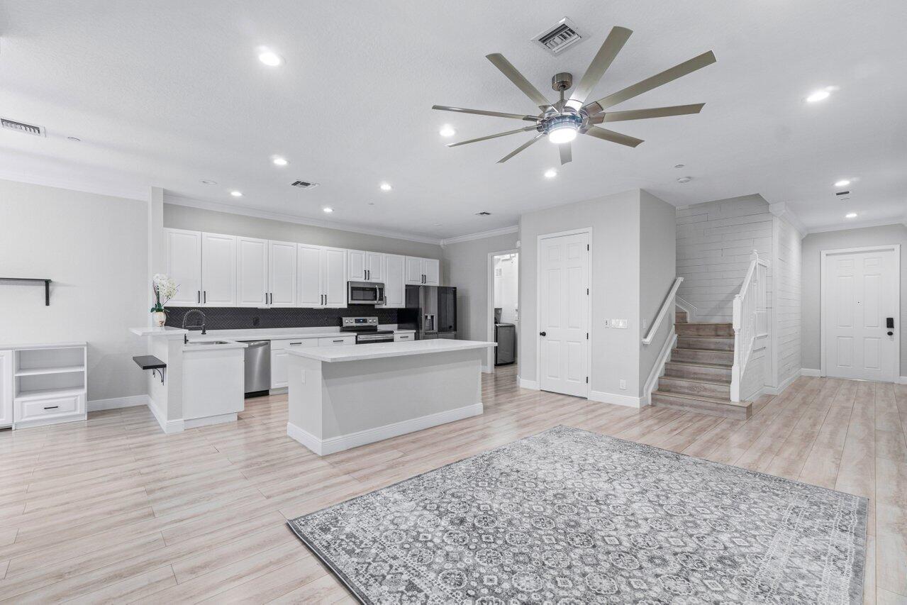 a open kitchen with white cabinets a sink and a stove