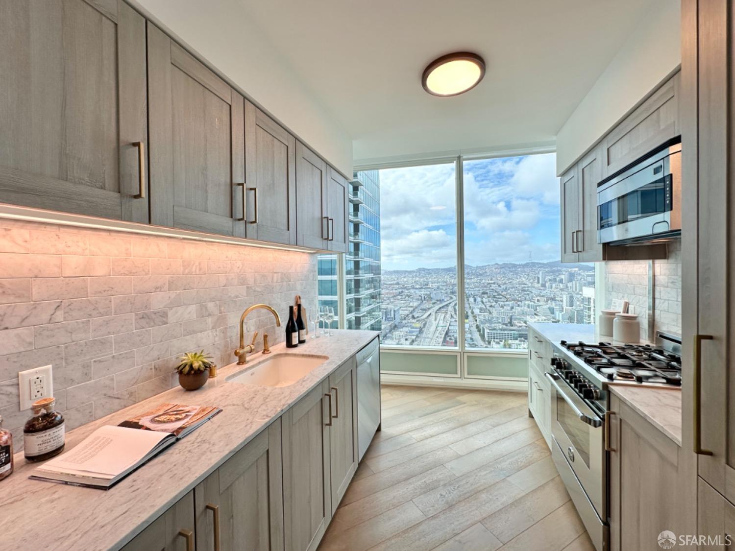 a kitchen with stainless steel appliances a stove a sink and a refrigerator