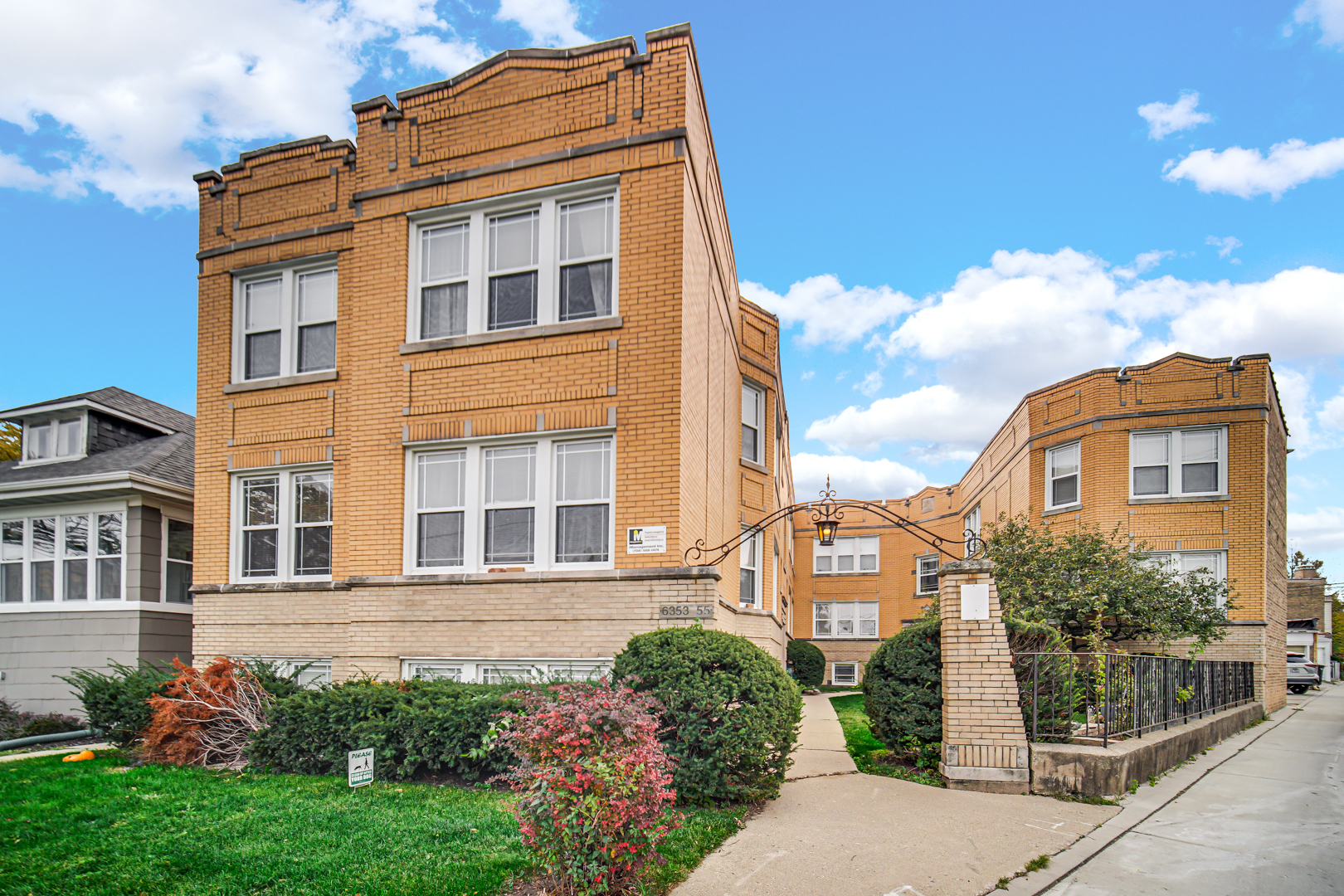 a front view of a residential apartment building with a yard