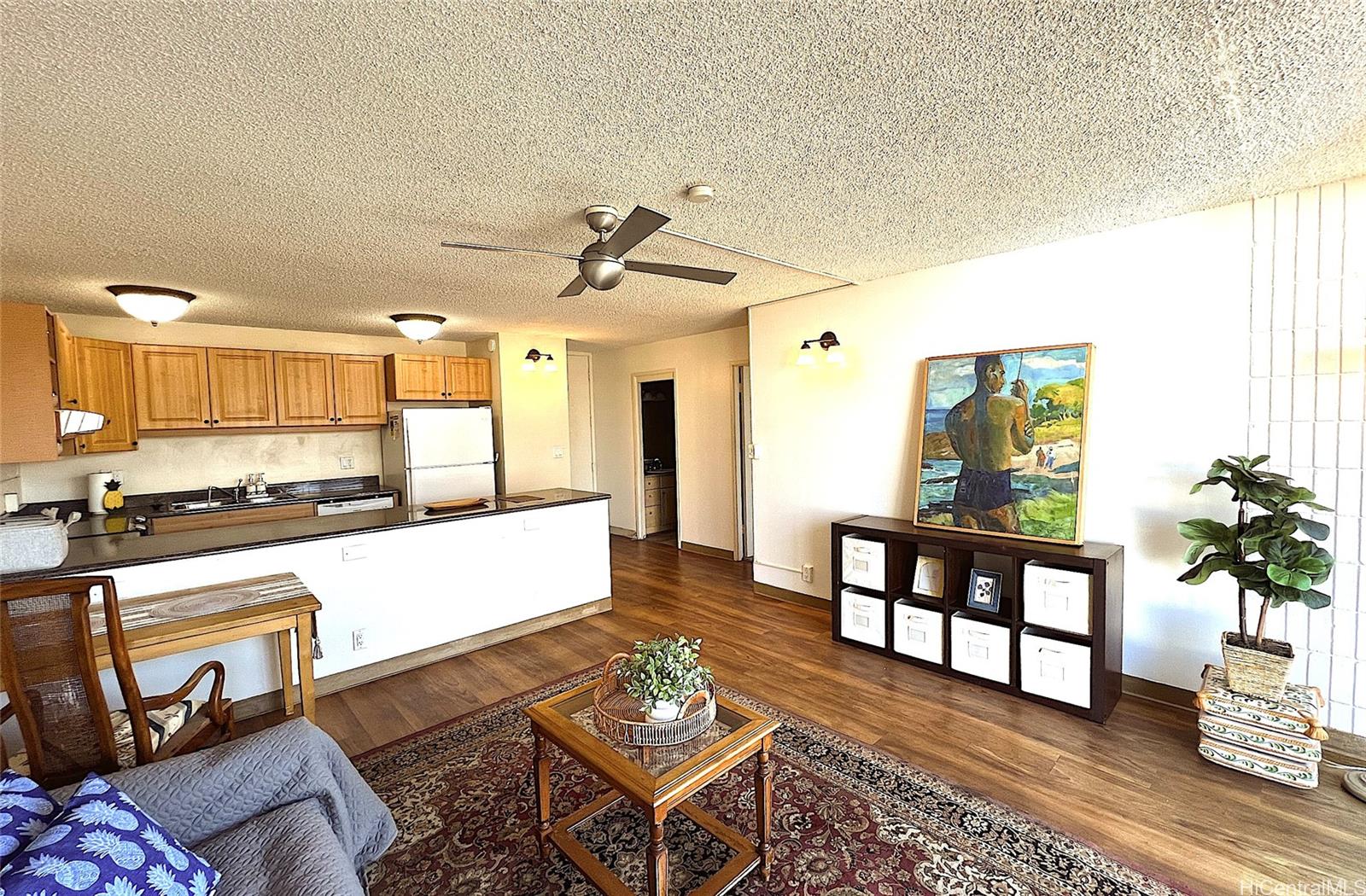 a living room with furniture and a dining table with wooden floor