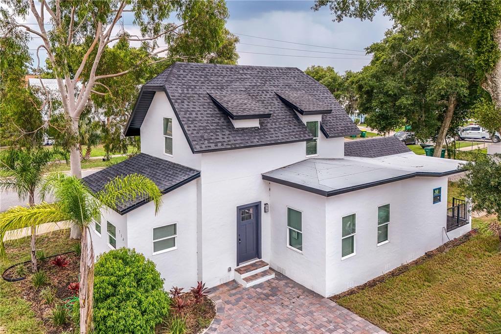 a aerial view of a house with a yard and large trees