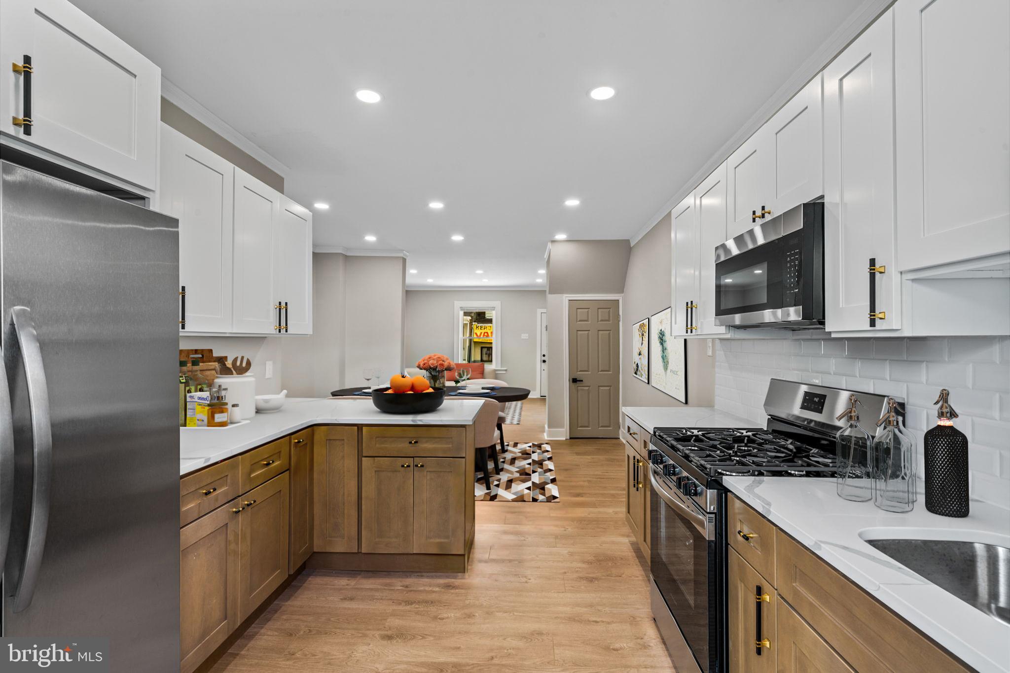 a kitchen with stainless steel appliances granite countertop a sink stove refrigerator and cabinets