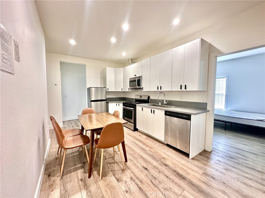 a kitchen with stainless steel appliances granite countertop a white cabinets and wooden floor