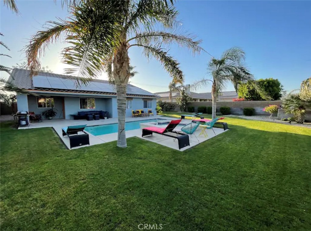 a view of a backyard with table and chairs potted plants and a palm tree