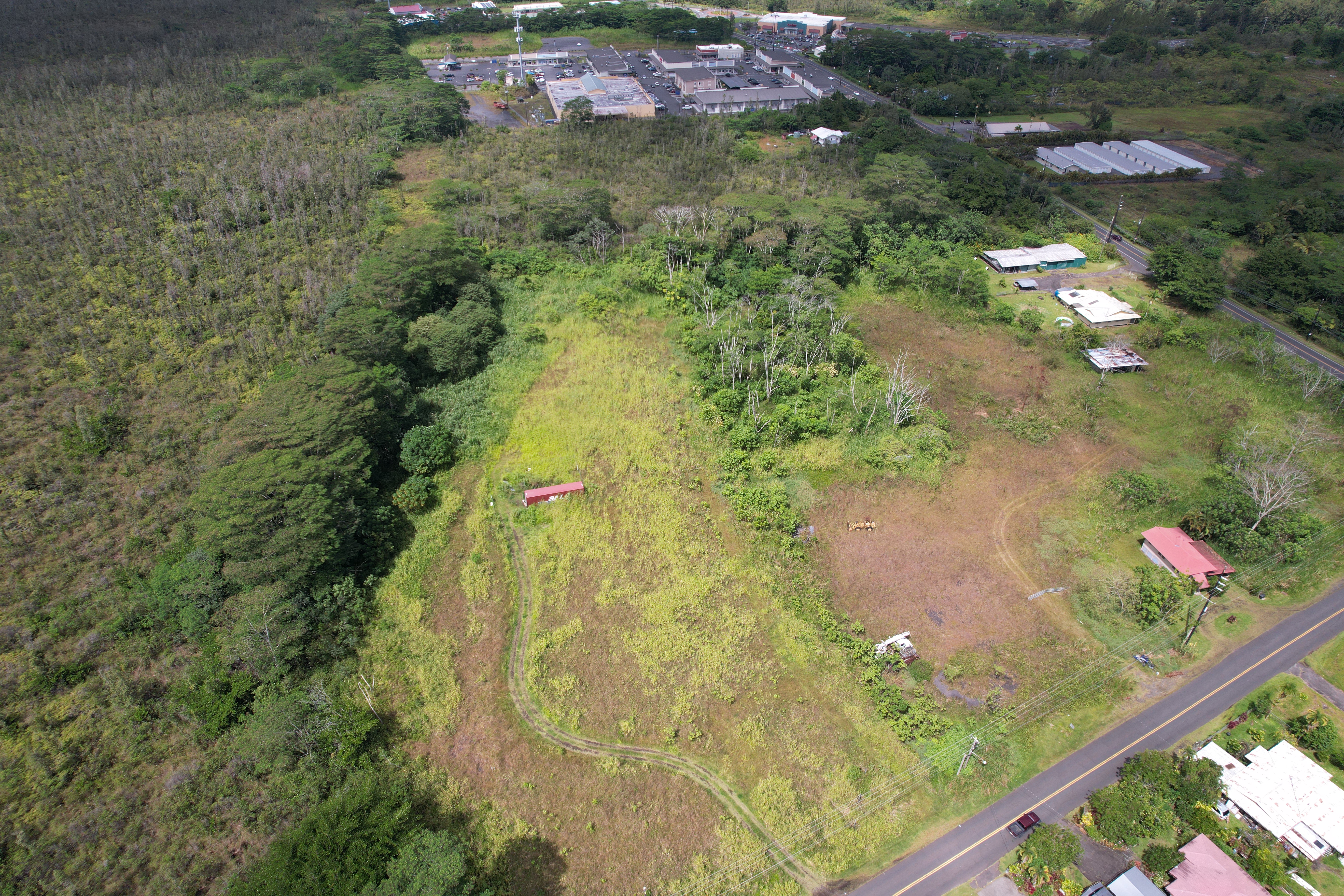 Vacant land on Apaa Rd with Puna Kai Shopping Center in view behind the property, highlighting its close proximity to many shopping and dining options.