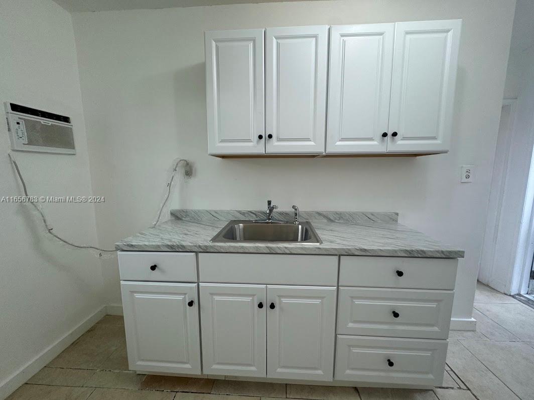 a kitchen with white cabinets and a sink