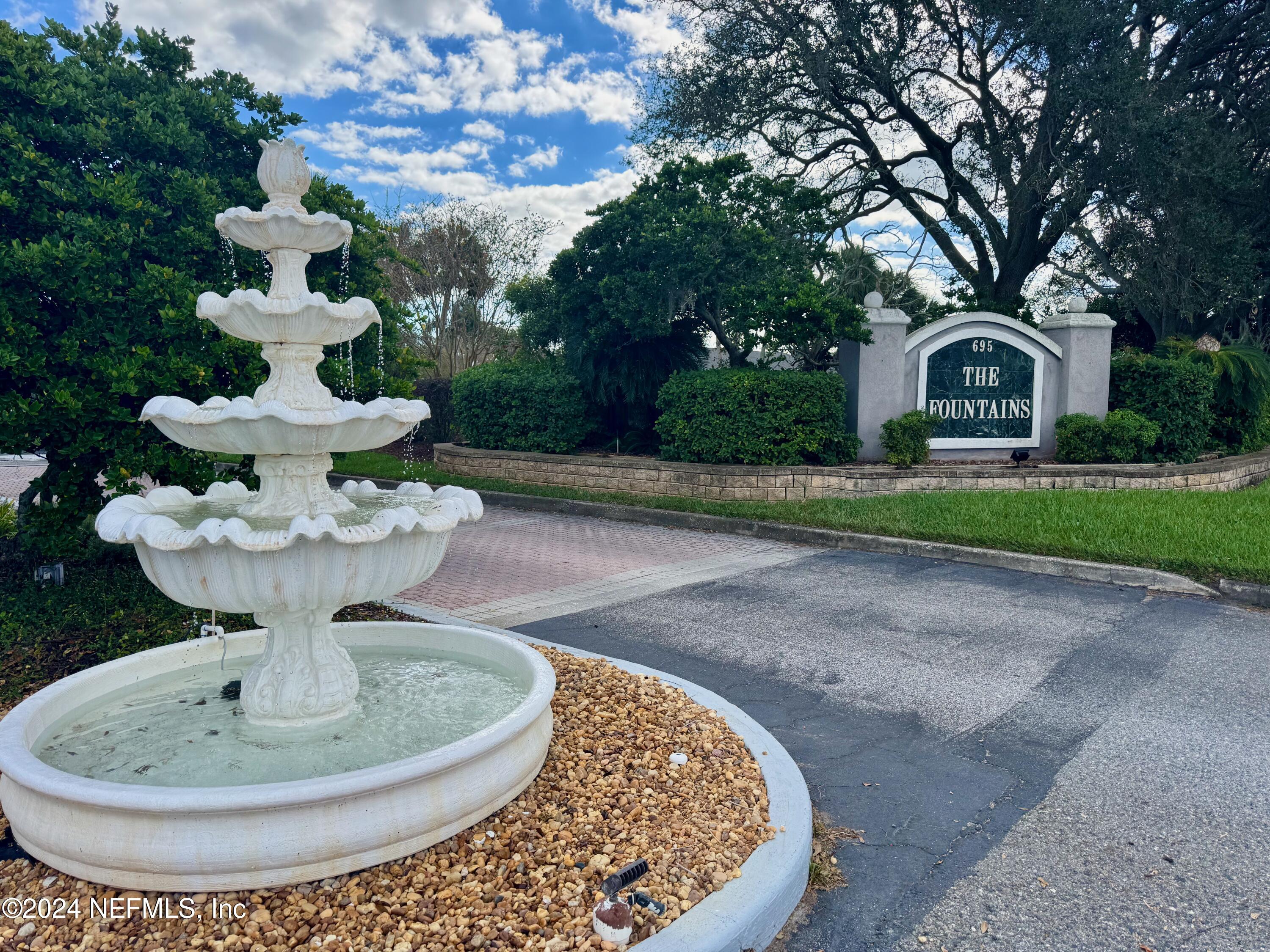 a view of a house with a fountain in it