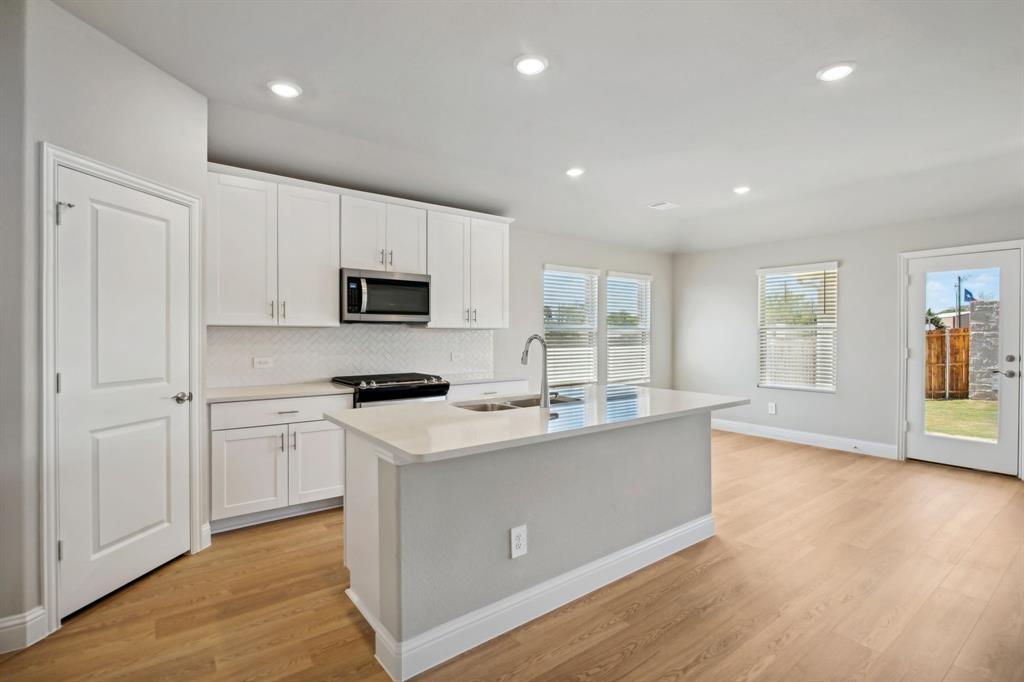 a kitchen with a sink cabinets and wooden floor