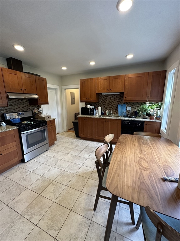 a kitchen with stainless steel appliances kitchen island granite countertop a sink and cabinets