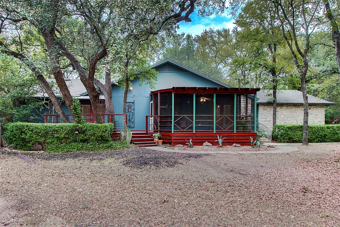 a view of a house with a small yard and large tree