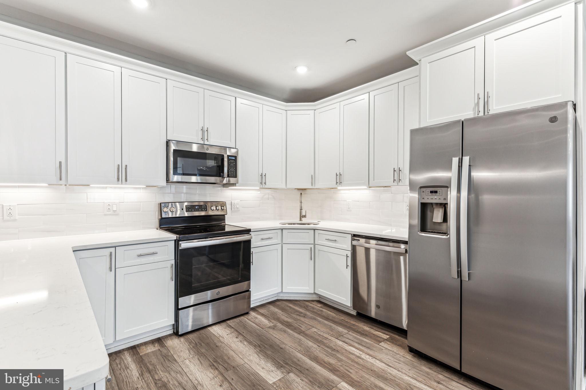 a kitchen with cabinets stainless steel appliances and a counter space