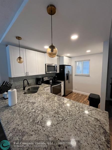 a kitchen with sink refrigerator and microwave