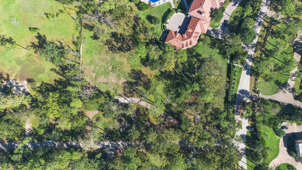 an aerial view of residential house with outdoor space and trees all around