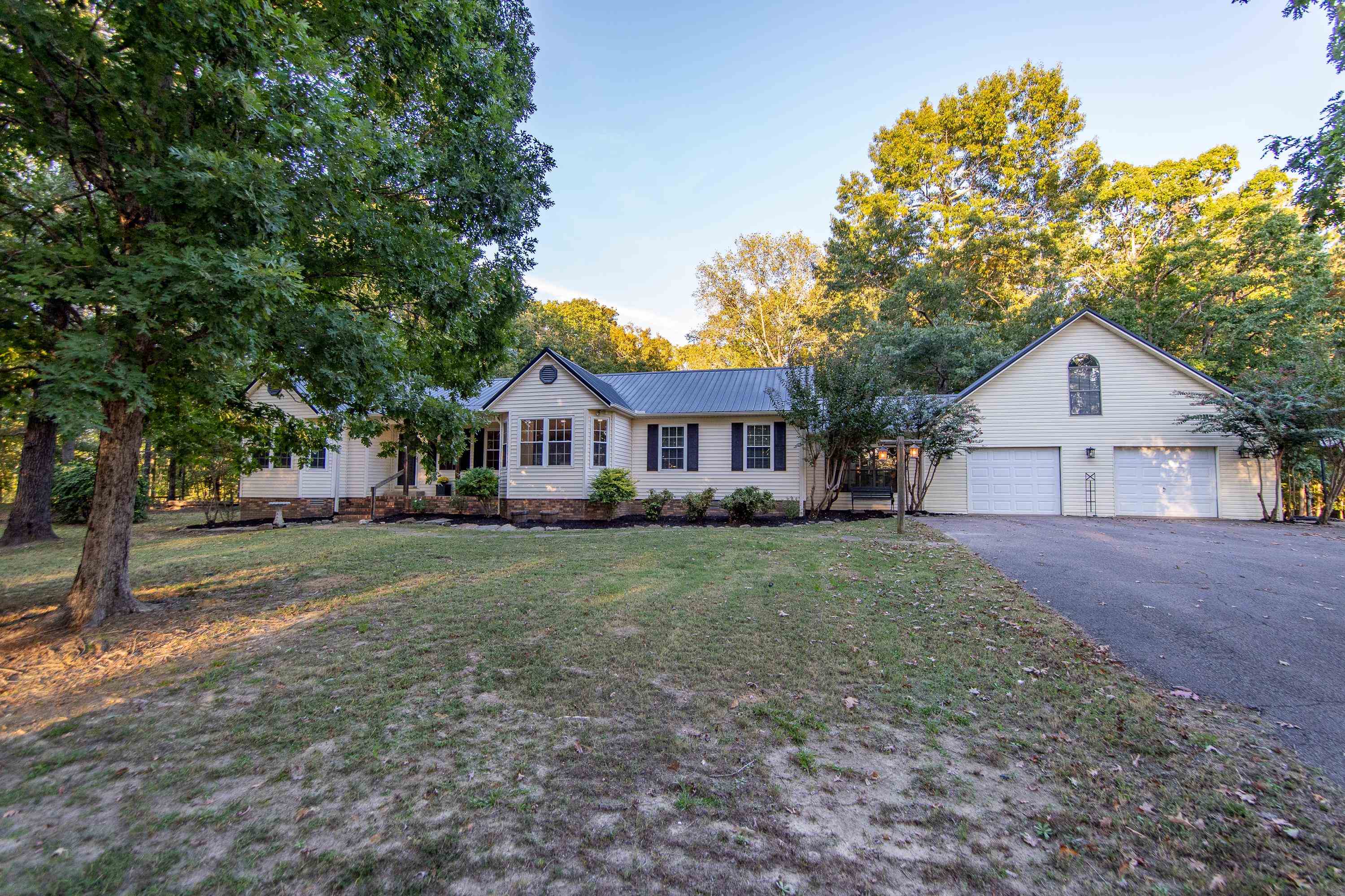 a front view of a house with a yard and trees