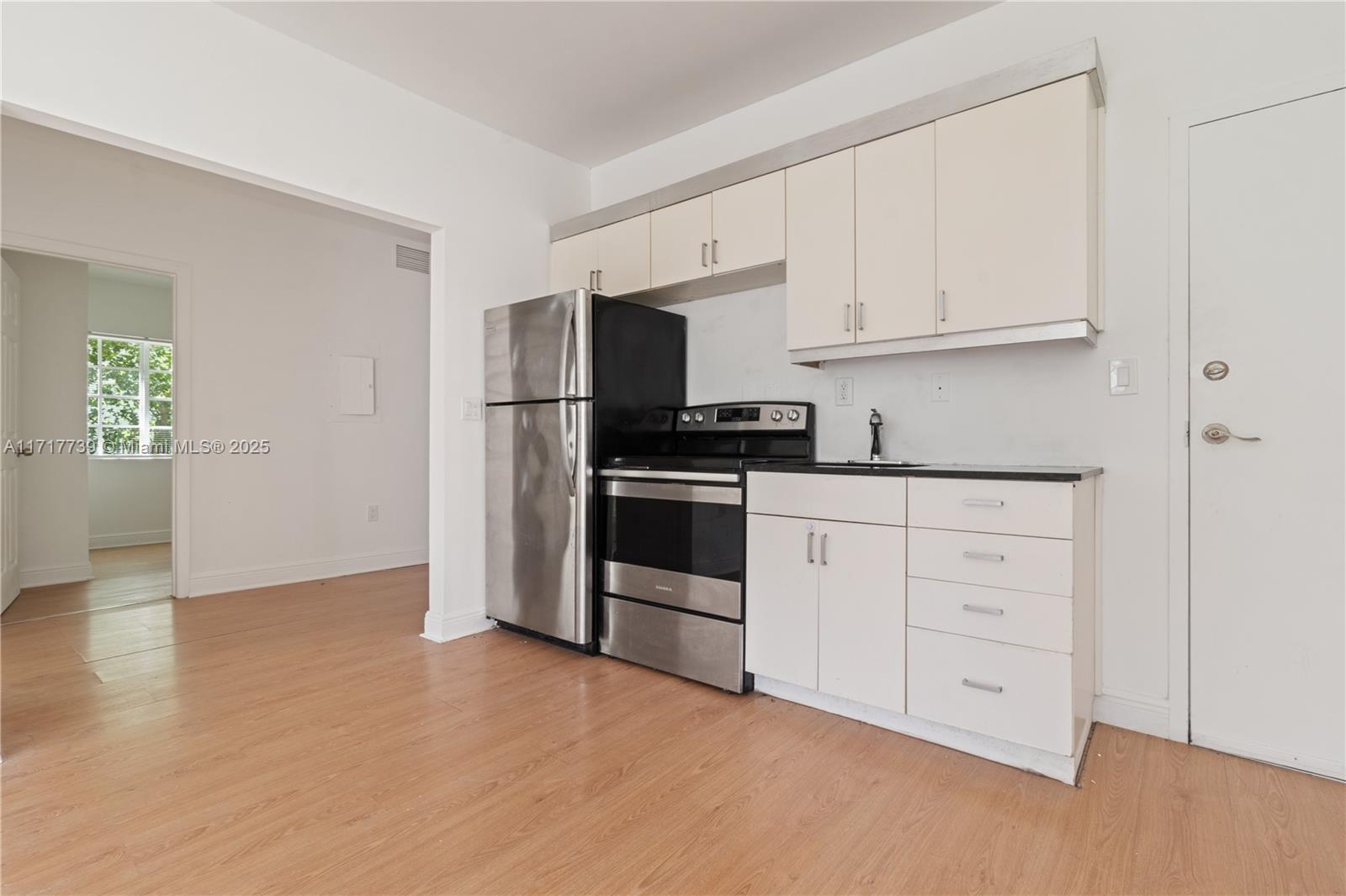 a kitchen with white cabinets and stainless steel appliances