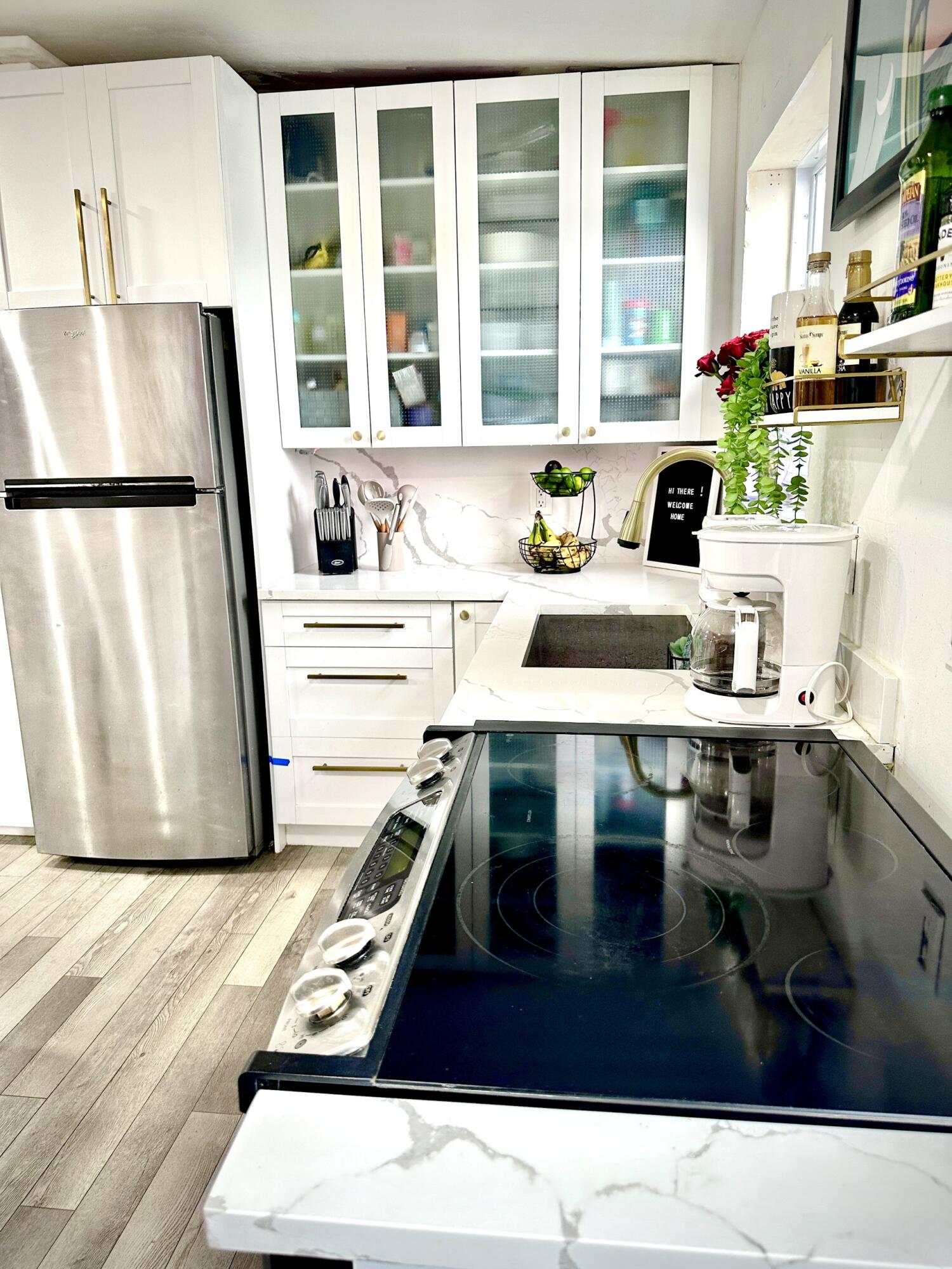 a kitchen with a stove a refrigerator and a sink with wooden floor