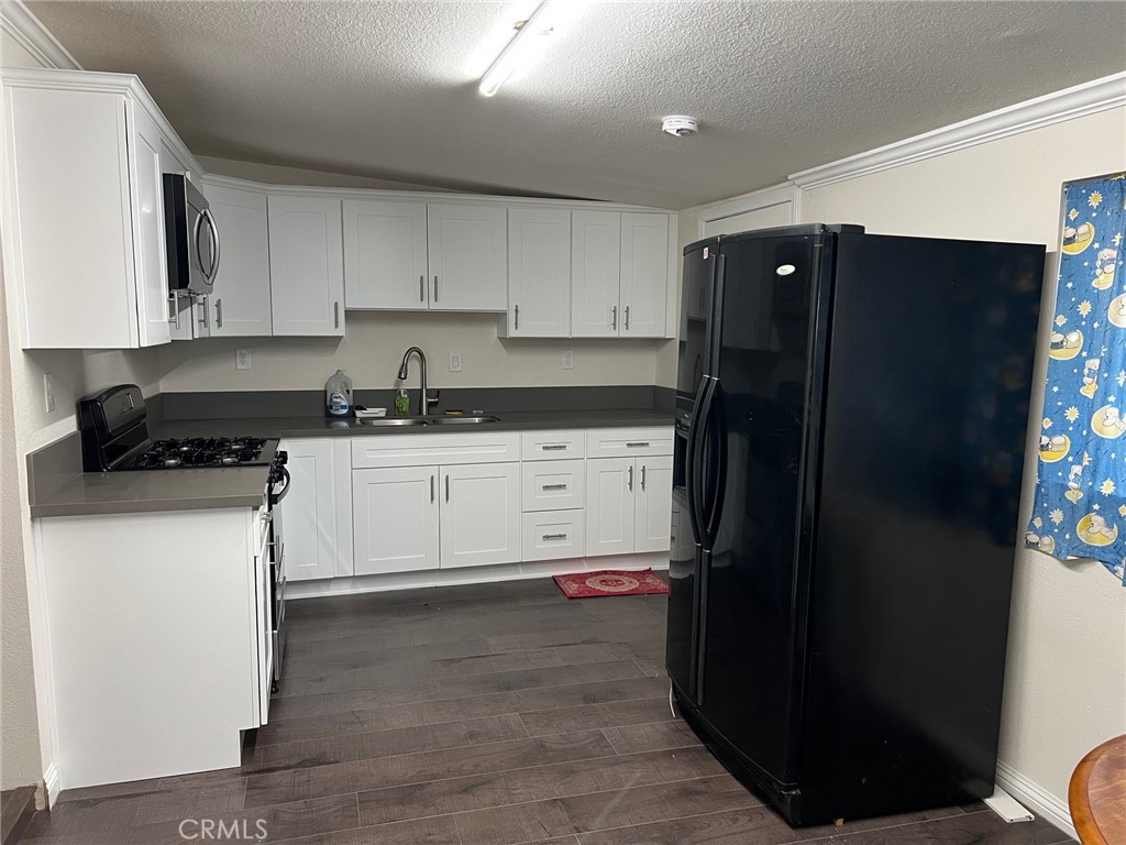 a kitchen with a sink a refrigerator and cabinets