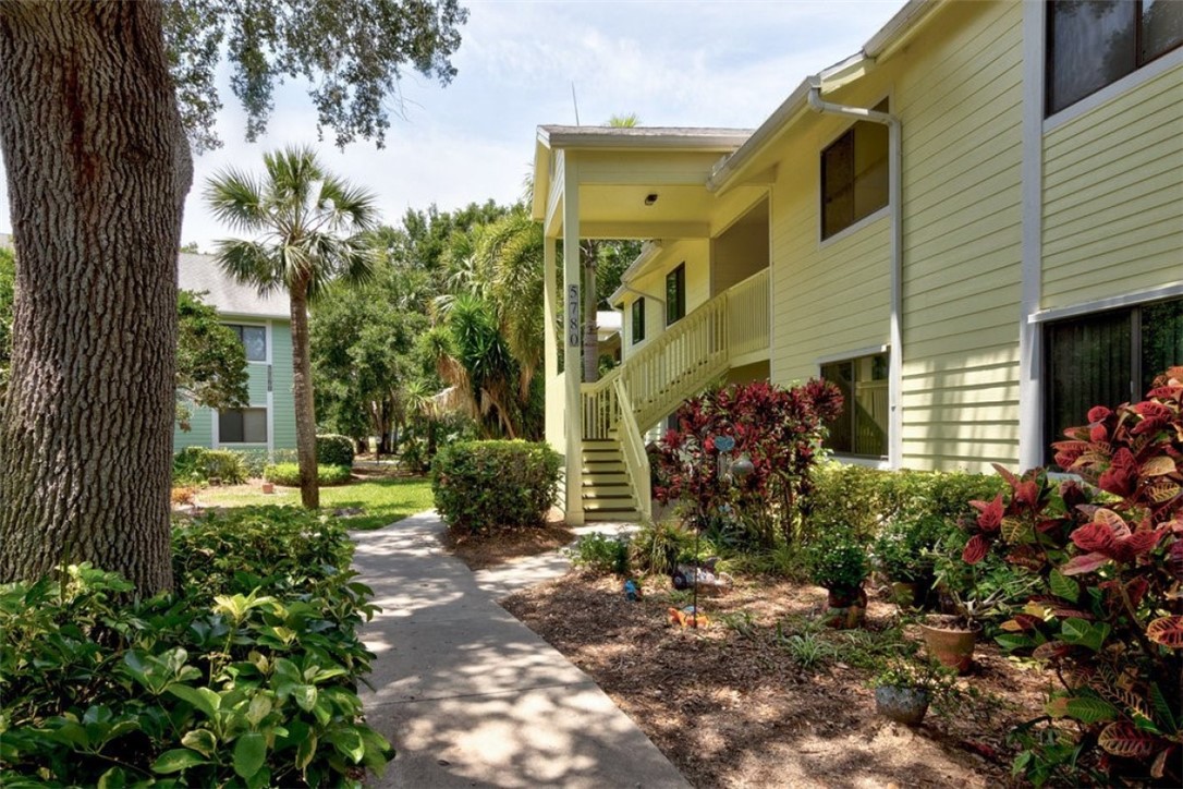 a view of a house with a tree and flower plants