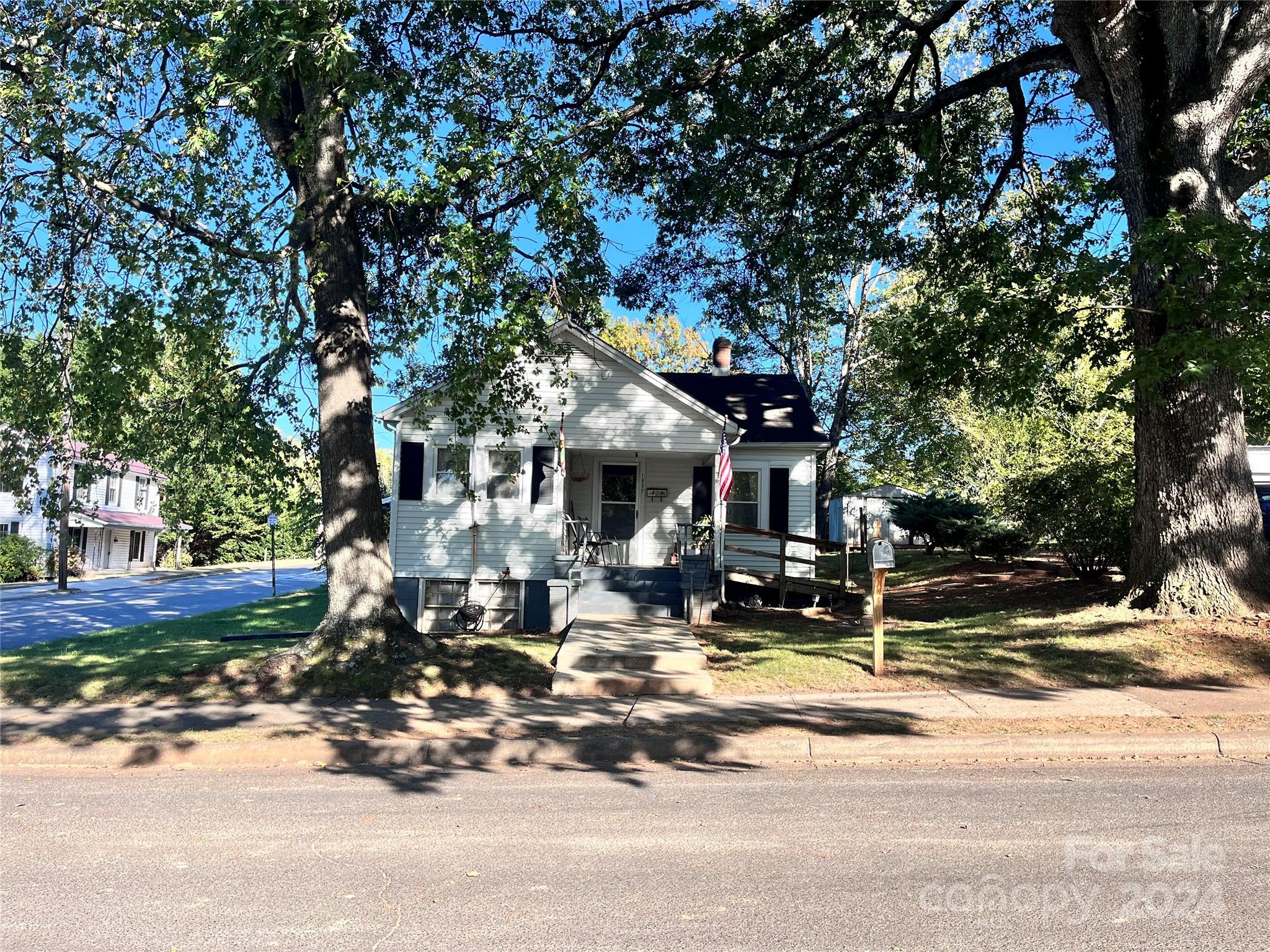 a front view of a house with a tree