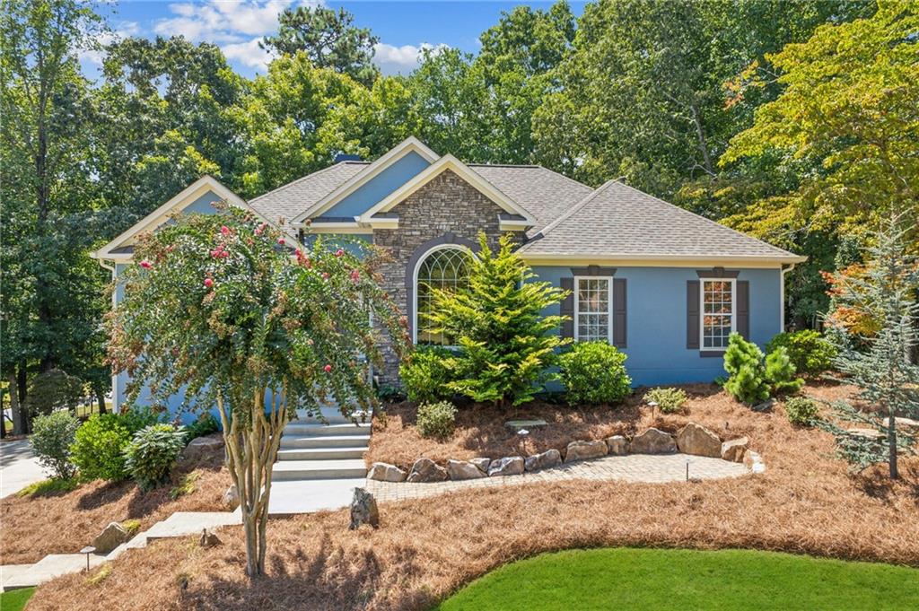 a front view of a house with a yard and potted plants