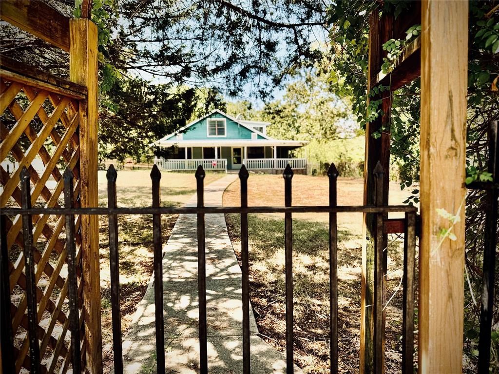 a front view of a house with large trees