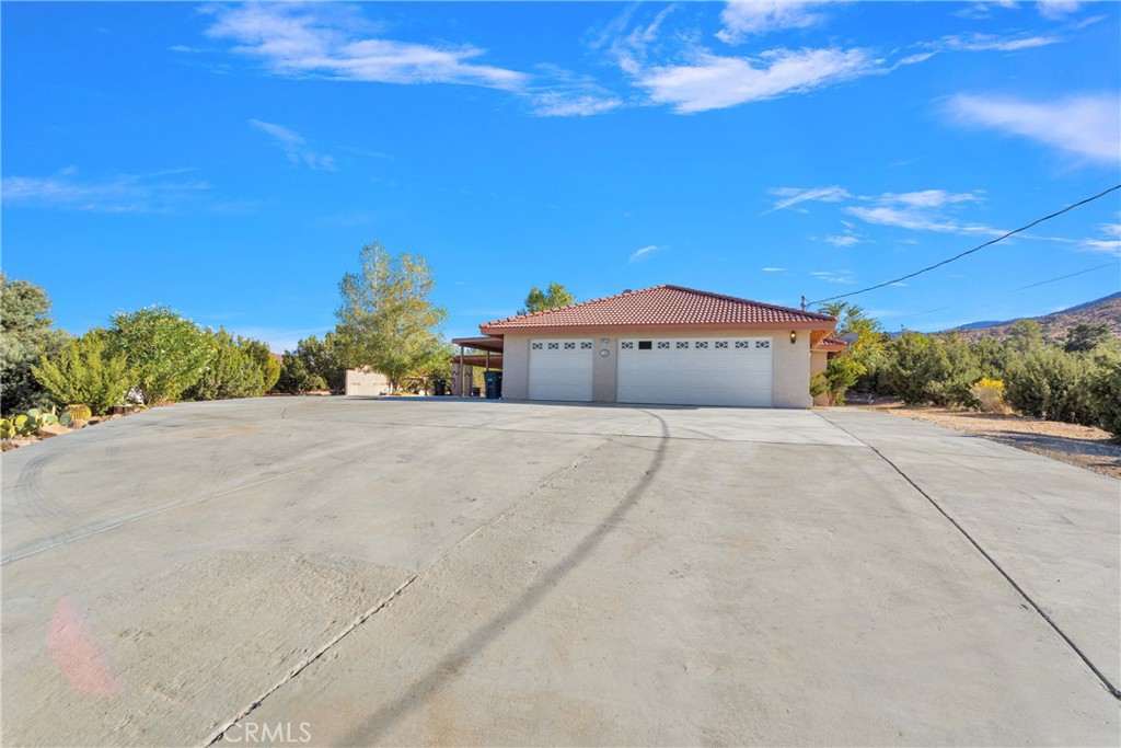 a front view of a house with a yard and mountain view