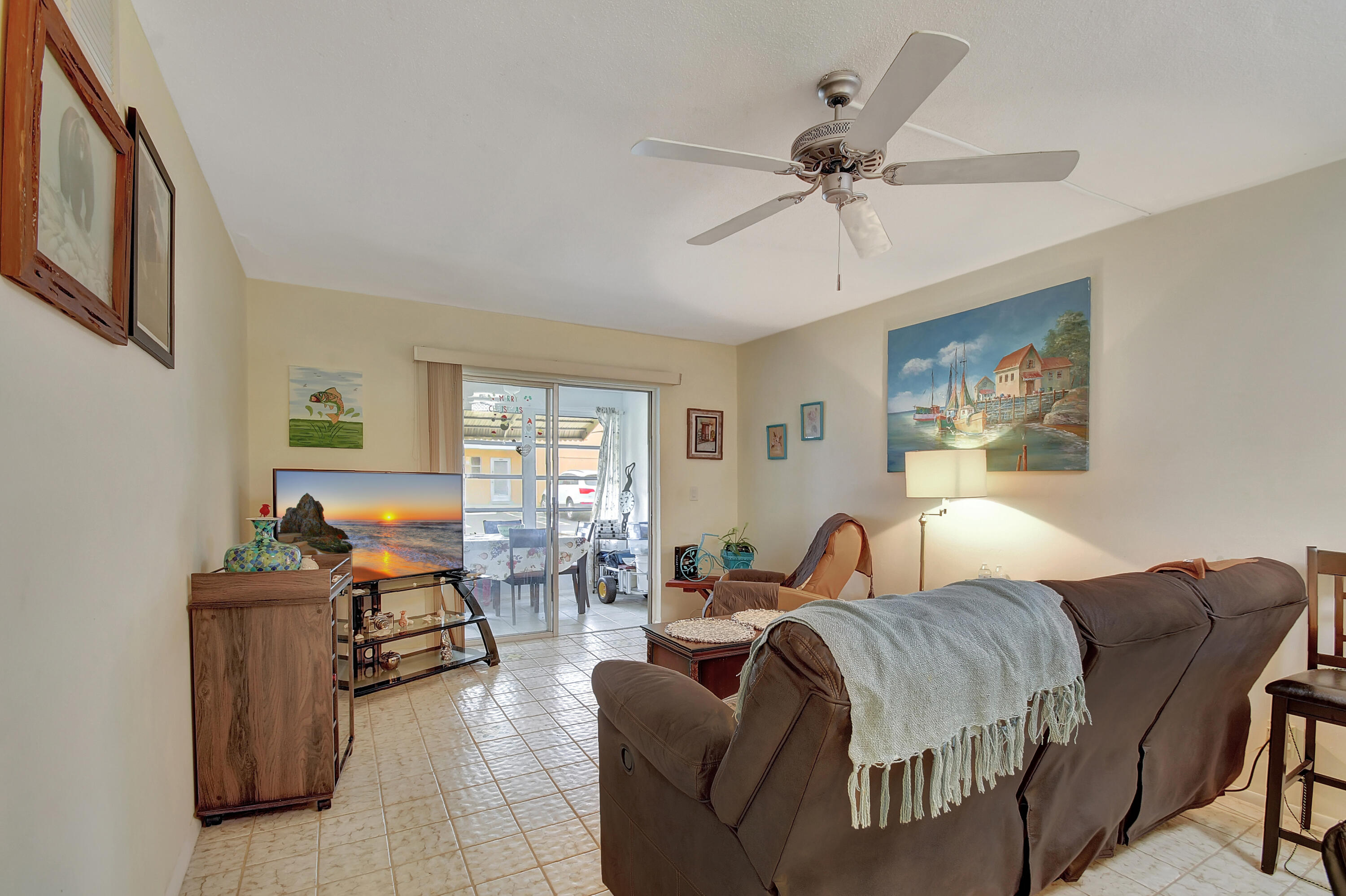 a living room with furniture a ceiling fan and a window