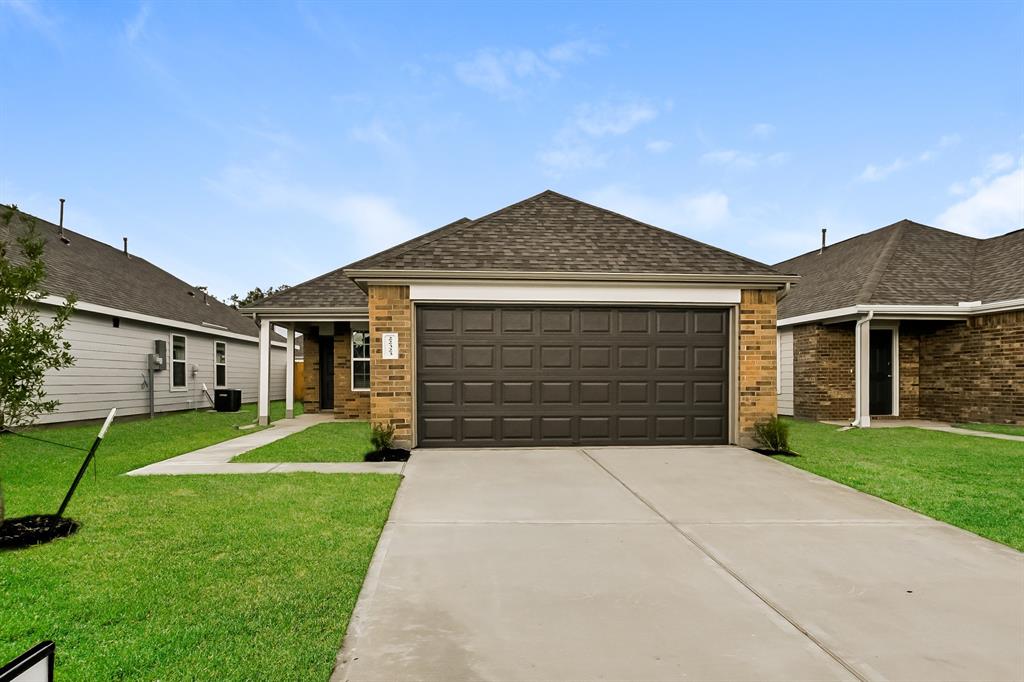 a front view of a house with a yard and garage