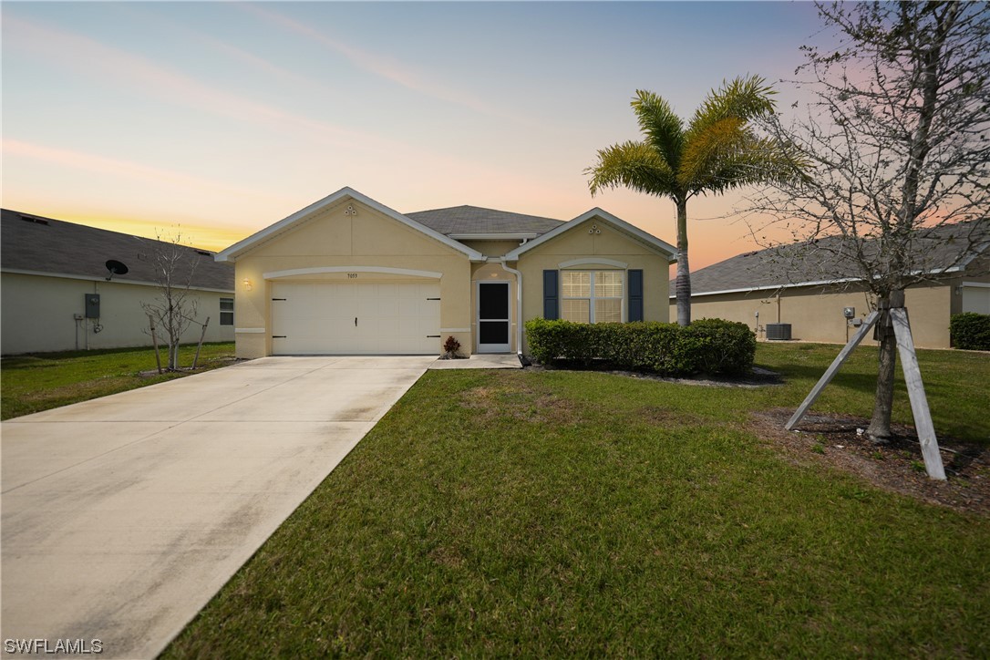 a view of a house with a yard and palm trees