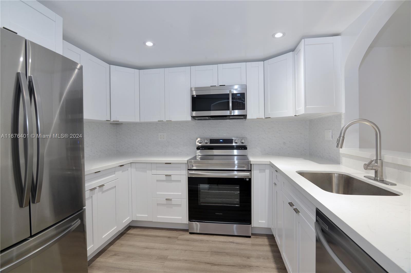 a kitchen with stainless steel appliances granite countertop a refrigerator sink and microwave