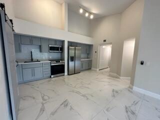 a large kitchen with stainless steel appliances granite countertop a sink and cabinets