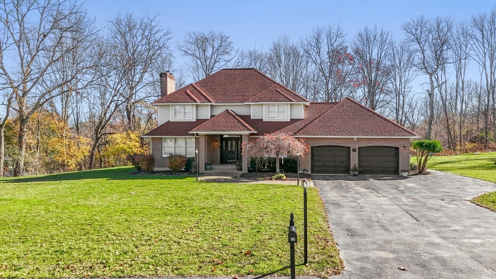 a front view of house with yard and trees