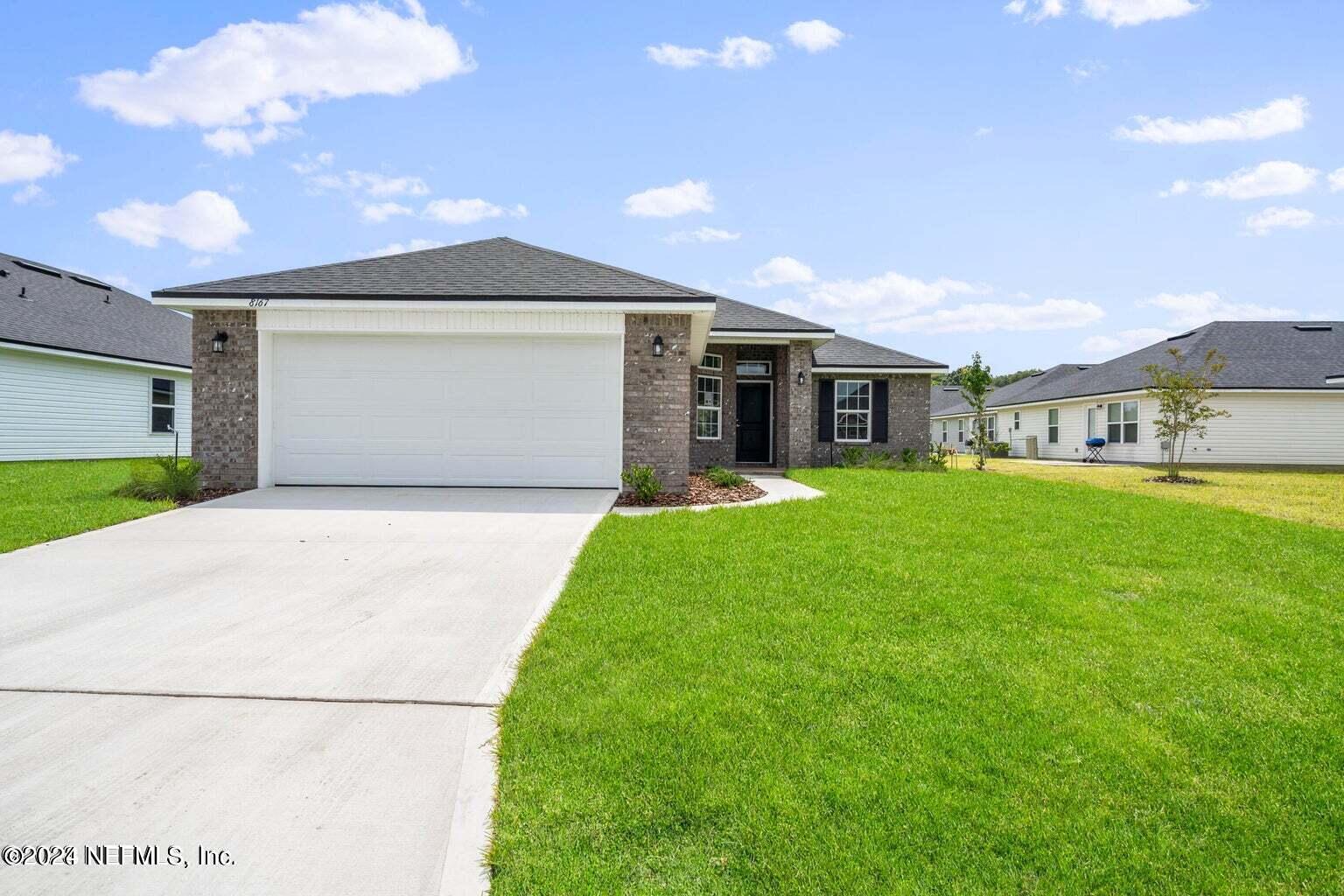 a front view of a house with a yard and garage