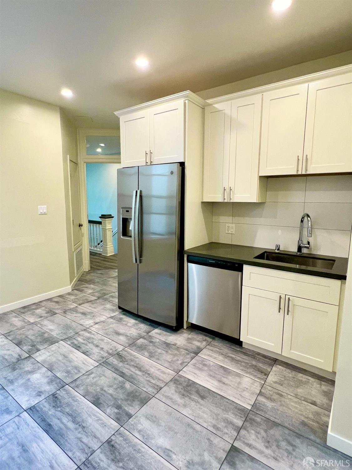 a kitchen with stainless steel appliances granite countertop a refrigerator and a sink