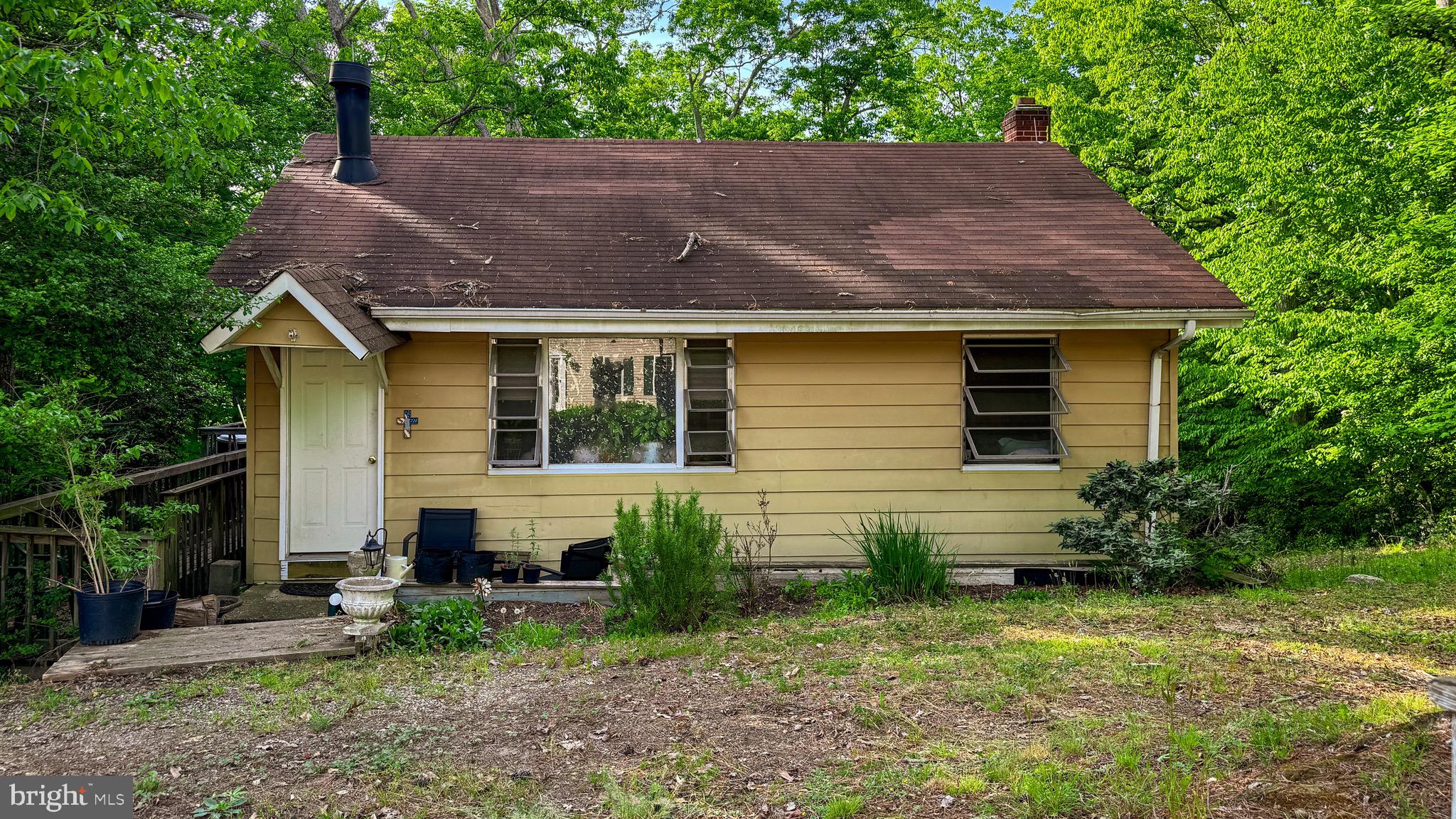 a view of house with a yard and a garden