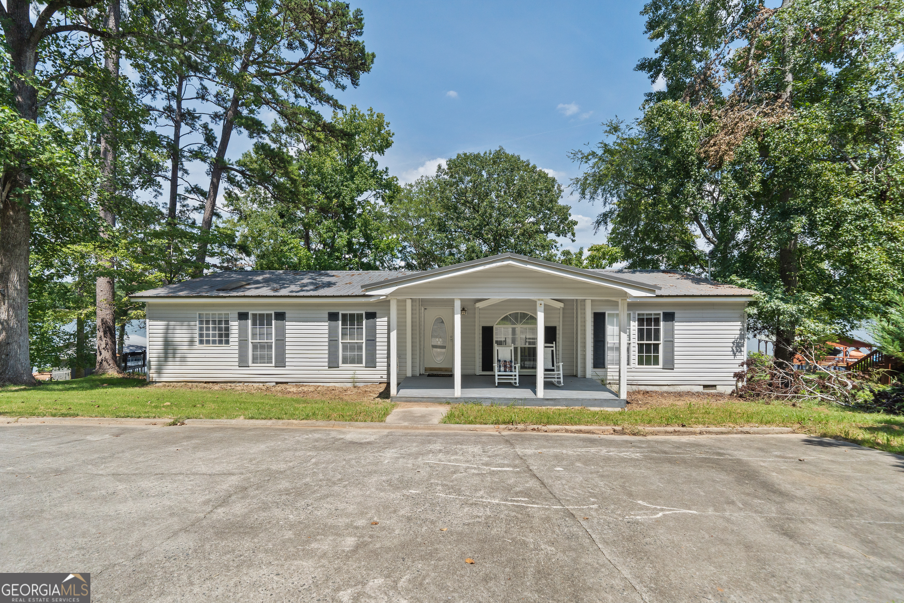 a front view of a house with a yard and trees