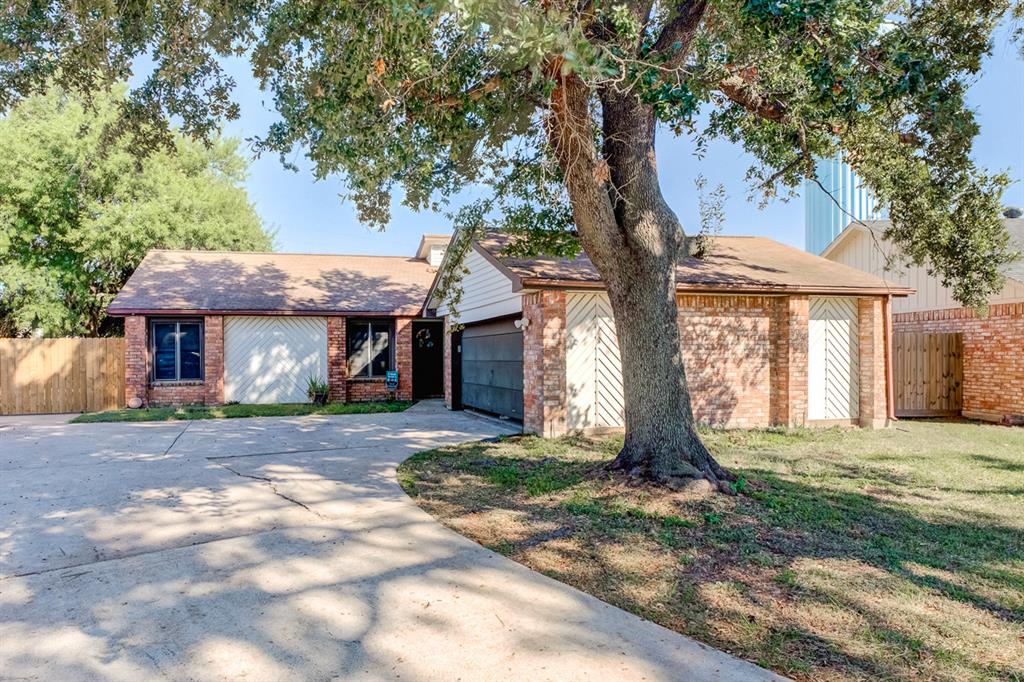 a view of a house with a tree in front of it