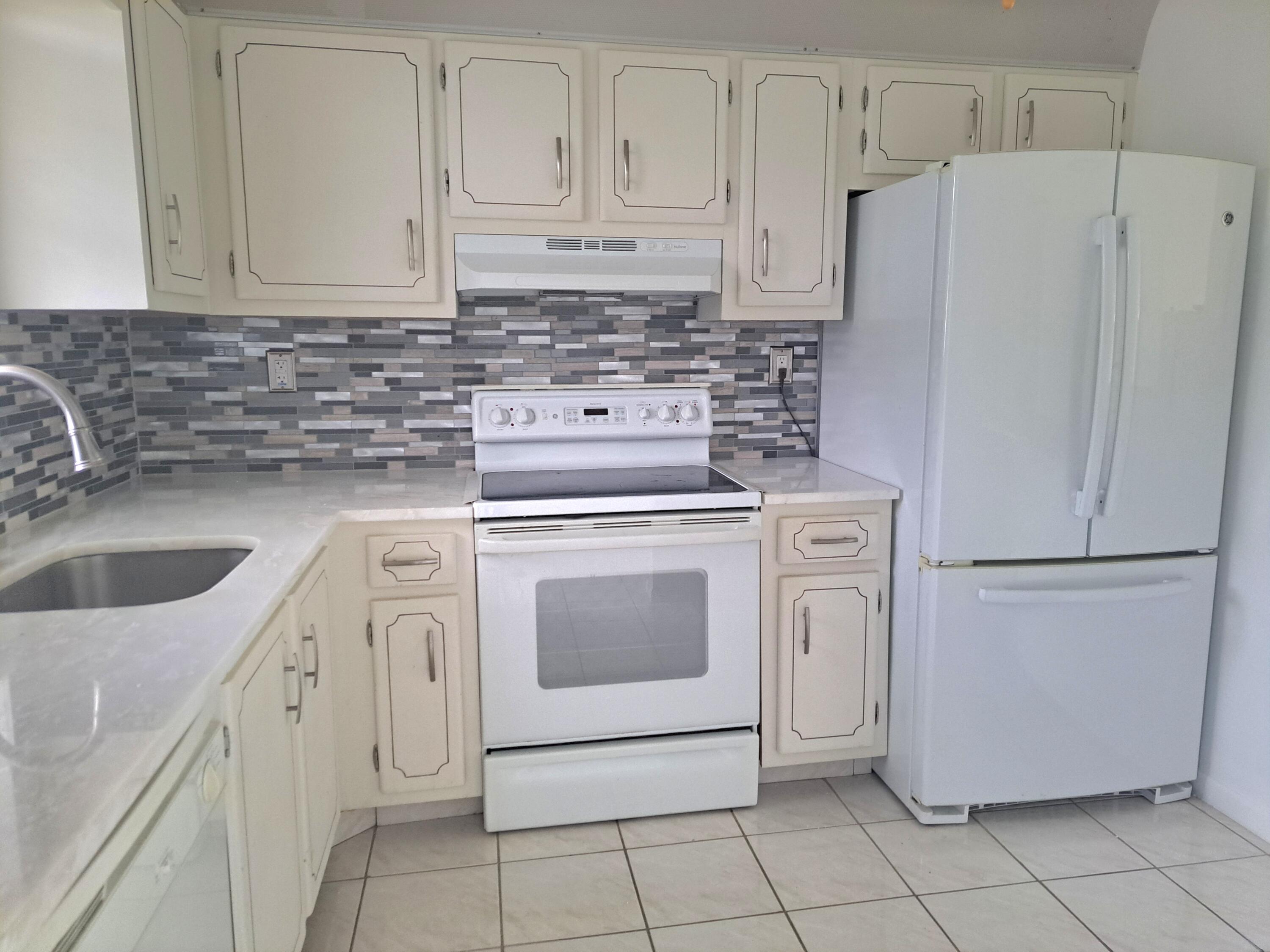 a kitchen with cabinets a refrigerator and a sink