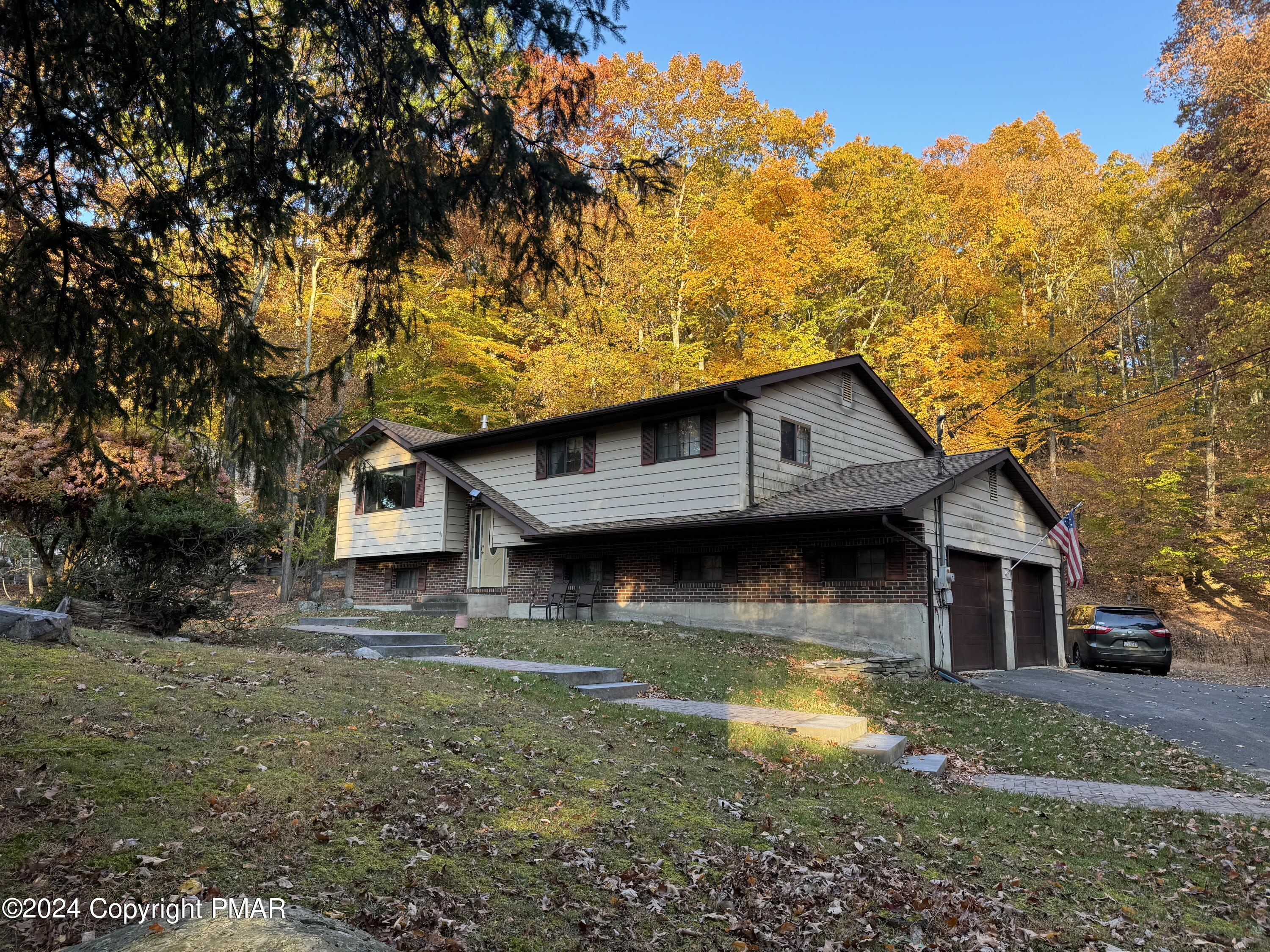 a view of a house with pool and a yard