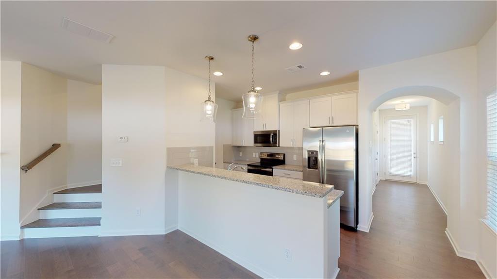 a kitchen with stainless steel appliances a refrigerator sink and stove