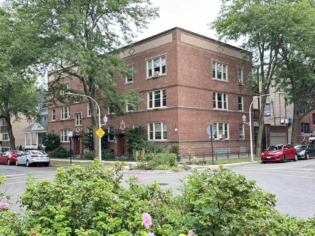 a front view of a building with cars parked