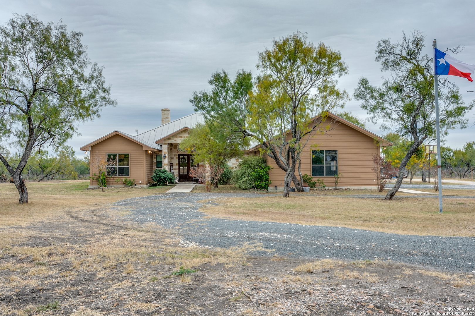 a front view of a house with a yard and trees