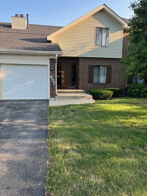 a view of a house with a yard and garage