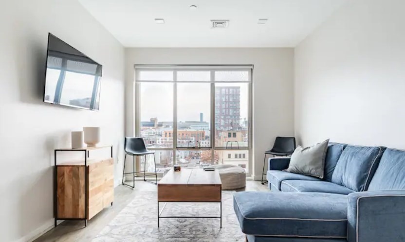 a living room with furniture and a floor to ceiling window