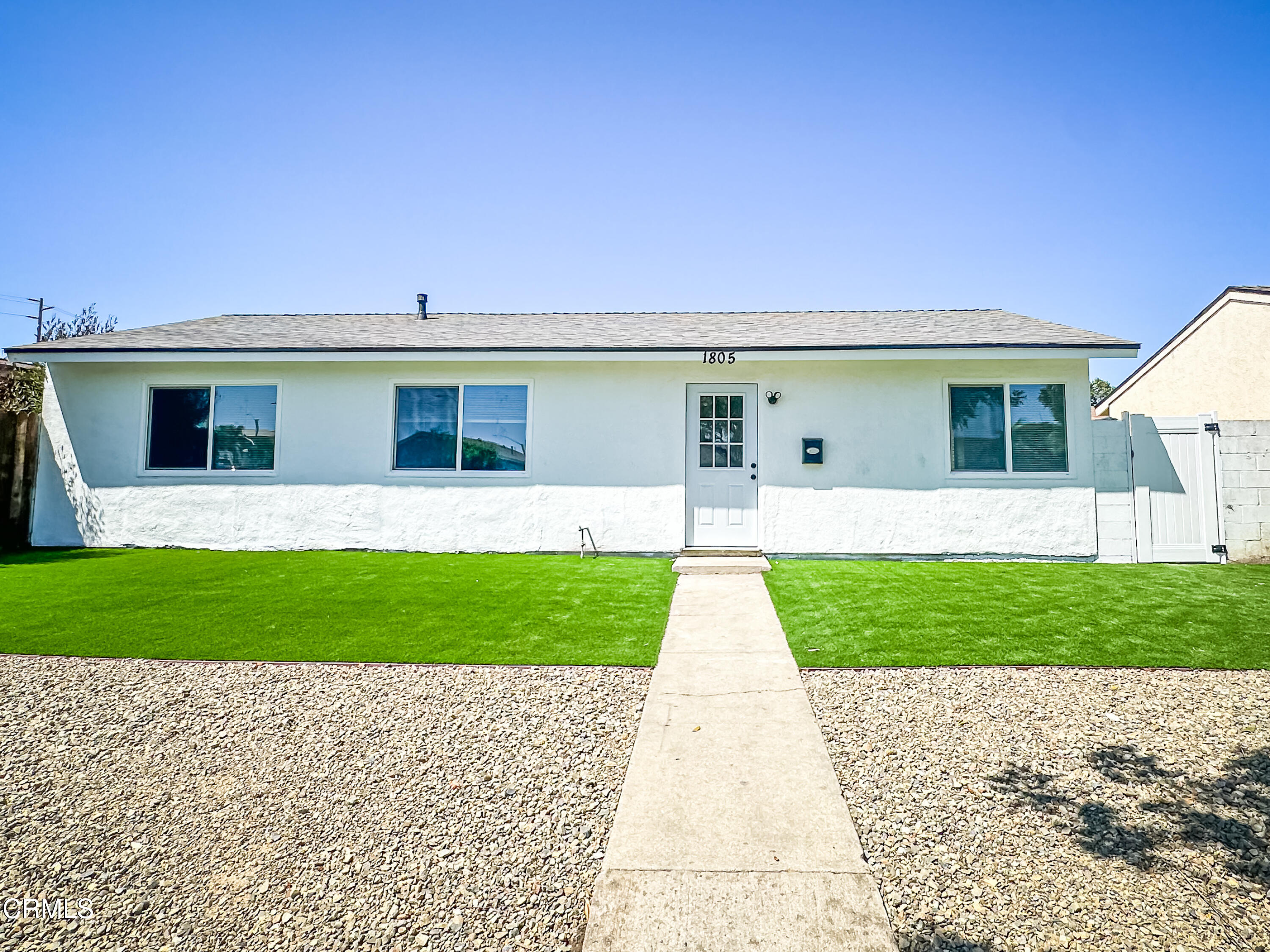 a front view of a house with a garden and yard