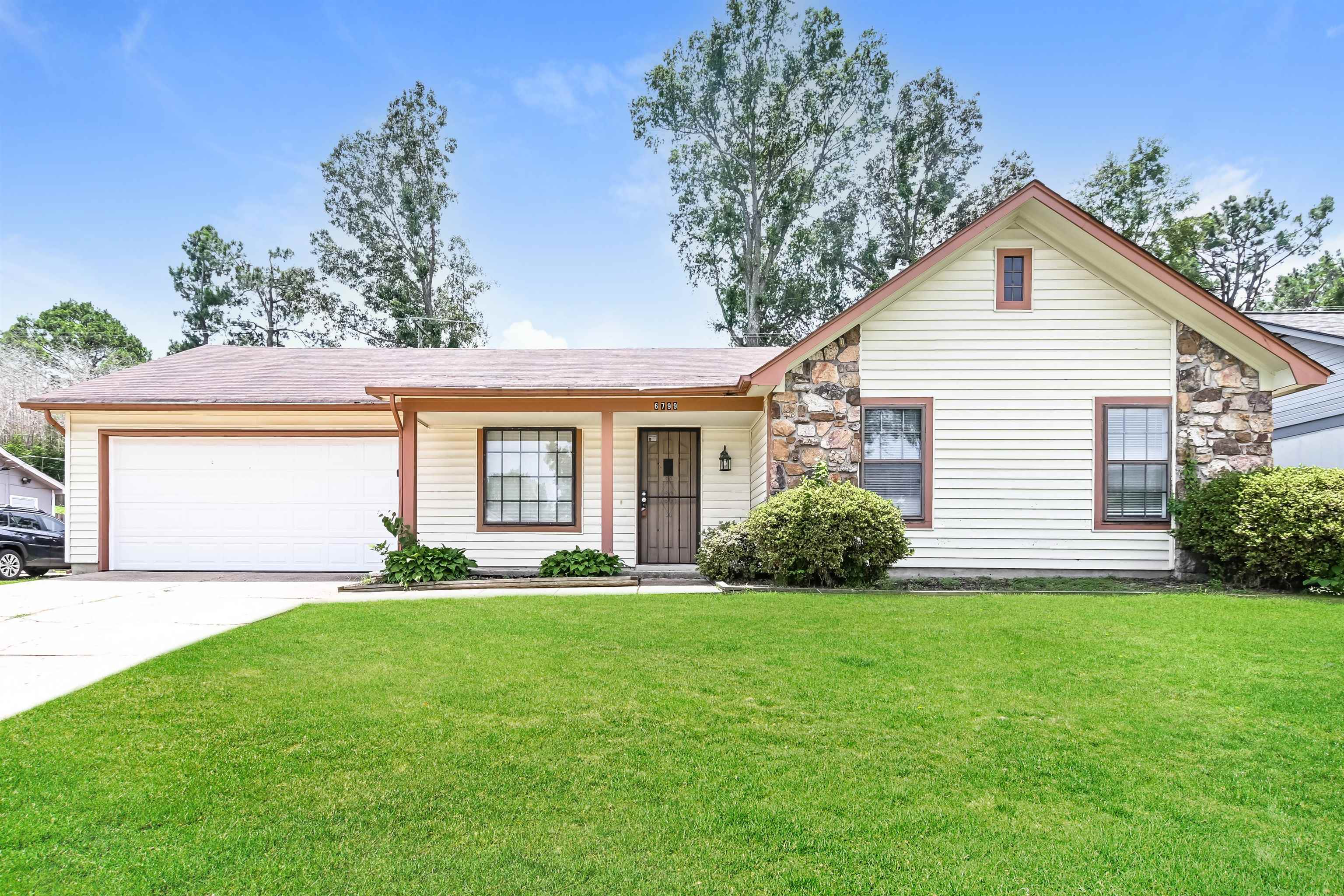 Ranch-style home featuring a garage and a front yard