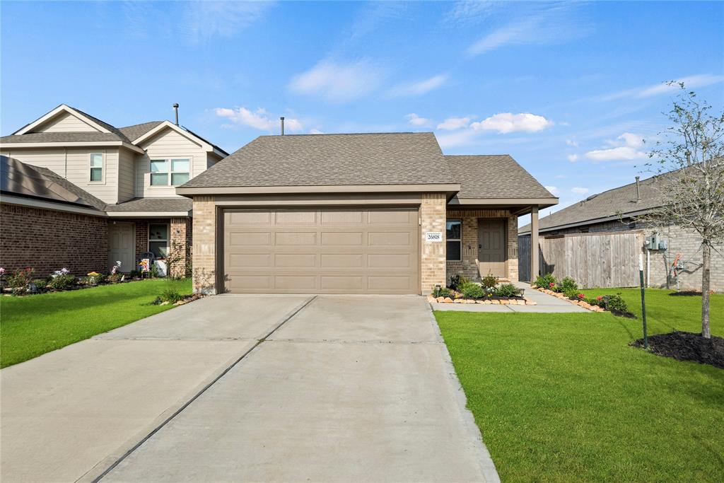 a front view of a house with a yard and garage